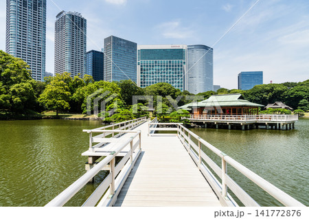 Across Otsutaibashi Bridge to the Shioiri-no-ike (Tidal Pond) is Nakajima no Ochaya in the Hama-rikyu Garden in Chuo City, Tokyo, Japan, with the skyscrapers of Shiodome. Across Otsutaibashi Bridge to the Shioiri-no-ike (Tidal Pond) is Nakajima no Ochaya in the Hama-rikyu Garden in Chuo City, Tokyo, Japan, with the skyscrapers of Shiodome. 141772876