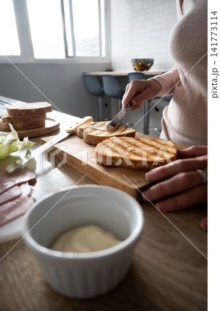 Preparing a grilled ham and cheese sandwich Preparing a grilled ham and cheese sandwich 141773114