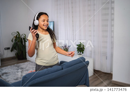 Girl listening music and dancing with smartphone 141773476