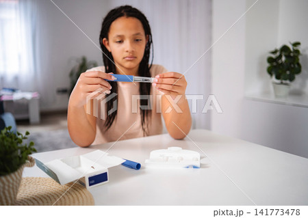 Young girl learning to use insulin pen for diabetes management 141773478