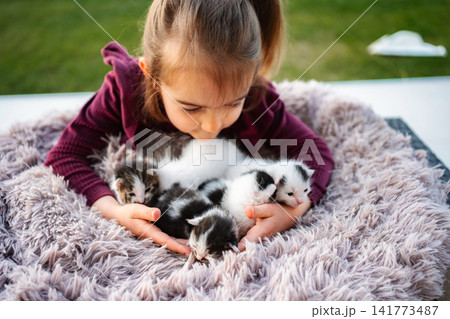 Little girl holding newborn kittens showing empathy and pet care Little girl holding newborn kittens showing empathy and pet care 141773487