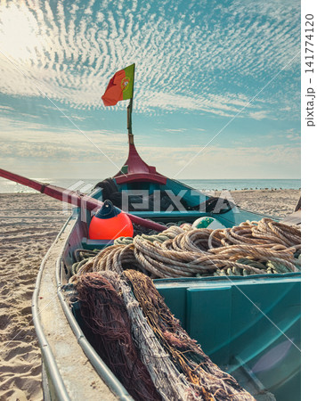 Traditional Arte Xavega fishing boat on sand beach Traditional Arte Xavega fishing boat on sand beach 141774120