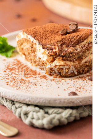 Slice of tiramisu dessert cake with coffee beans Slice of tiramisu dessert cake with coffee beans 141774121