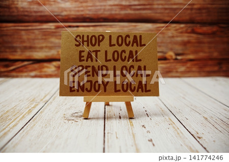 Shop Local, Eat Local, Spend Local, Enjoy Local text message with easel on wooden background 141774246
