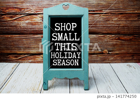 Shop Small This Holiday Season text message with easel on wooden background 141774250