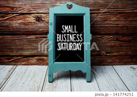 Small Business Saturday text message with easel on wooden background Small Business Saturday text message with easel on wooden background 141774251