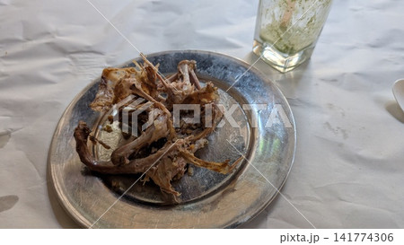 Leftover pigeon bones on a plate after a traditional Egyptian meal Leftover pigeon bones on a plate after a traditional Egyptian meal 141774306