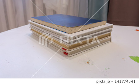 Notebooks Arranged On Smooth Surface. Serene Workspace Featuring Stacked Notebooks Illuminated By Gentle Daylight. Calm And Organized Home Study Area With Precise Edges And Vibrant Page Indicators Notebooks Arranged On Smooth Surface. Serene Workspace Featuring Stacked Notebooks Illuminated By Gentle Daylight. Calm And Organized Home Study Area With Precise Edges And Vibrant Page Indicators 141774341