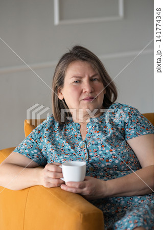 Contemplative Lady With Cozy Drink. Bridge Of Calmness With Warm Beverage And Peaceful Surroundings. Tranquil Female Figure Sitting Contentedly With Comforting Drink By Bright Sunny Window Contemplative Lady With Cozy Drink. Bridge Of Calmness With Warm Beverage And Peaceful Surroundings. Tranquil Female Figure Sitting Contentedly With Comforting Drink By Bright Sunny Window 141774348