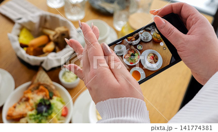 Capturing Breakfast Arrangement With Mobile Device. Photographing Brunch Setup Using Smartphone From Above. Taking Overhead Pictures Of Breakfast Layout With Mobile Phone Under Natural Sunlight Capturing Breakfast Arrangement With Mobile Device. Photographing Brunch Setup Using Smartphone From Above. Taking Overhead Pictures Of Breakfast Layout With Mobile Phone Under Natural Sunlight 141774381