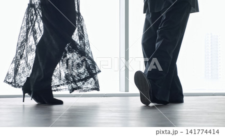 Silhouetted Dancers By Large Window, Lace Skirt And Tailored Trousers Visible, Soft Lighting, Urban Skyline Beyond Glass, Intimate Rehearsal Or Quiet Conversation, Elegant Footwear, Polished Floor Silhouetted Dancers By Large Window, Lace Skirt And Tailored Trousers Visible, Soft Lighting, Urban Skyline Beyond Glass, Intimate Rehearsal Or Quiet Conversation, Elegant Footwear, Polished Floor 141774414