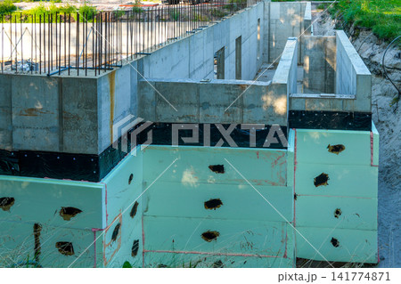 Concrete Foundation with XPS Insulation and Waterproofing at Residential Building Construction Site Concrete Foundation with XPS Insulation and Waterproofing at Residential Building Construction Site 141774871