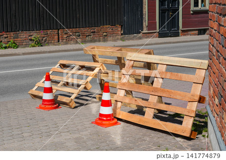 Wooden Shipping Pallets and Traffic Cones Blocking Sidewalk During Street Construction Safety Work Area Wooden Shipping Pallets and Traffic Cones Blocking Sidewalk During Street Construction Safety Work Area 141774879