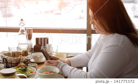 Calm Morning Reflection. Serene Lady Watches Outside Window. Gentle Female Enjoys Quiet Sunrise Moment By Window. Peaceful Lady Takes Moment To Reflect While Having Her Morning Meal Peacefully Calm Morning Reflection. Serene Lady Watches Outside Window. Gentle Female Enjoys Quiet Sunrise Moment By Window. Peaceful Lady Takes Moment To Reflect While Having Her Morning Meal Peacefully 141775372