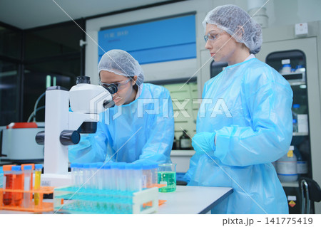 Female Scientists Analyzing Samples with Microscope in Laboratory Female Scientists Analyzing Samples with Microscope in Laboratory 141775419