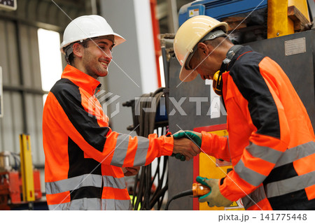 Male Industrial Worker Teamwork in in Safety Protective Gear operating industrial machinery with remote control or tablet. Male Industrial Worker Teamwork in in Safety Protective Gear operating industrial machinery with remote control or tablet. 141775448