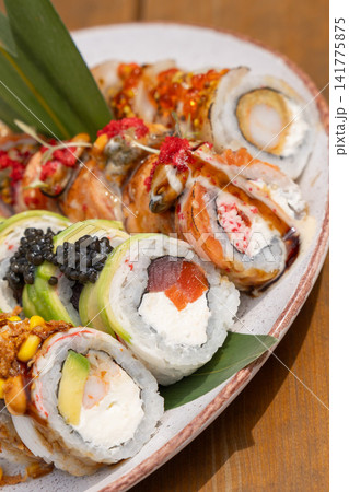 sushi roll platter featuring avocado, tuna, salmon, black caviar, shrimp, and various toppings sushi roll platter featuring avocado, tuna, salmon, black caviar, shrimp, and various toppings 141775875