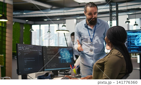 Pleased startup office manager applauding female programmer for optimizing code using AI. Satisfied team leader offering positive feedback to work done by IT specialist in office, camera A 141776360