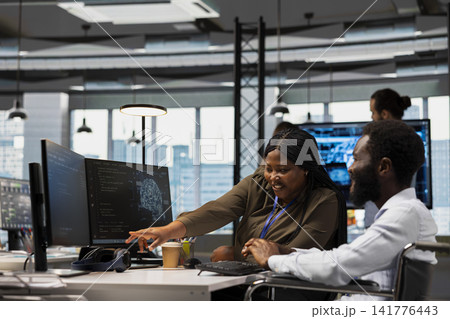 Teamworking programmer and man with paraplegia in office automating tasks with AI scripts. Happy IT expert and colleague in wheelchair using artificial intelligence to speed up feature implementation 141776443