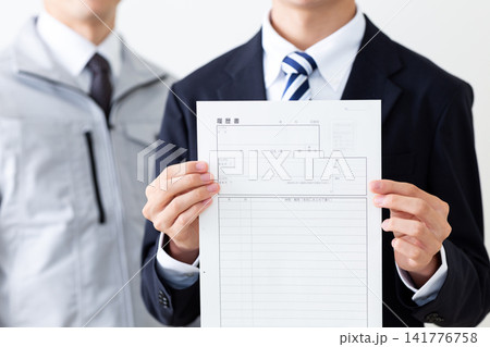 履歴書を持つリクルートスーツを着た若い男性と作業服のミドル男性 履歴書を持つリクルートスーツを着た若い男性と作業服のミドル男性 141776758