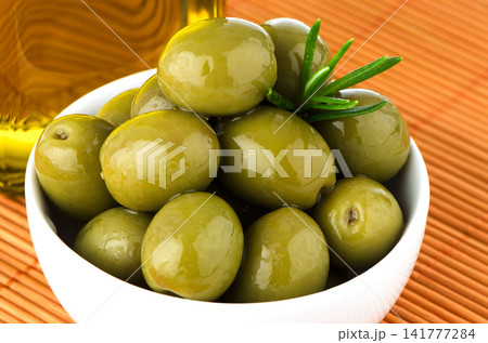 Green olives in a white ceramic bowl Green olives in a white ceramic bowl 141777284