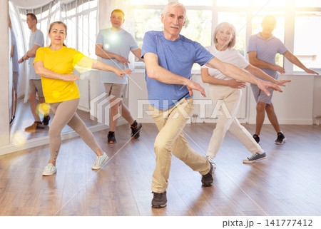 Elderly man dances modern dances in group Elderly man dances modern dances in group 141777412