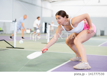 Concentrated young girl pickleball player waiting to receive serve 141777530