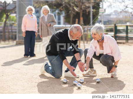 Group of elderly people playing petanque in courtyard Group of elderly people playing petanque in courtyard 141777531