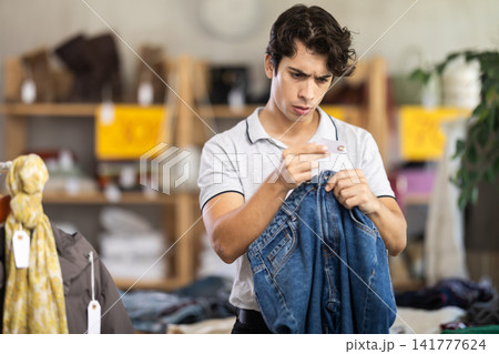In chain shop, young man choose jeans 141777624