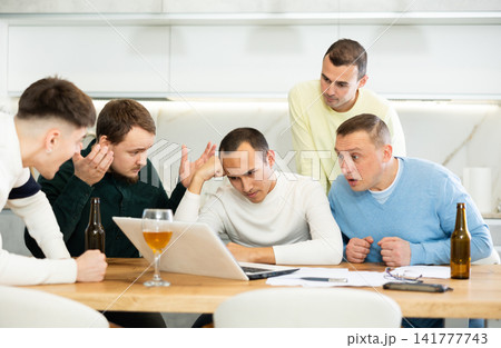 Worried male friends trying to solve problem together on laptop 141777743