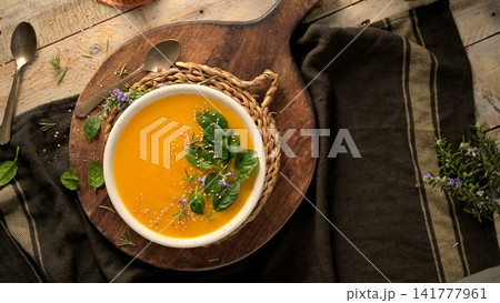 Cozy autumn pumpkin soup on a rustic wooden table Cozy autumn pumpkin soup on a rustic wooden table 141777961