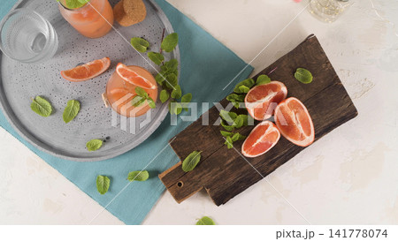 Grapefruit Infused Drink with Fresh Mint on a Wooden Board Grapefruit Infused Drink with Fresh Mint on a Wooden Board 141778074