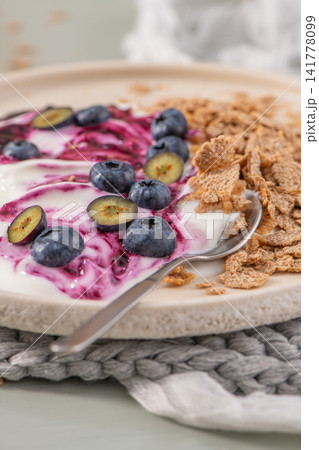 Healthy breakfast bowl with yogurt, berry compote, blueberries and cereal 141778099