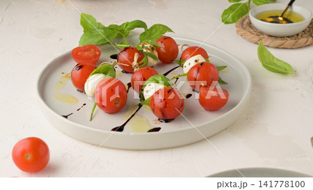 Caprese skewers with cherry tomatoes and mozzarella drizzled with balsamic glaze 141778100