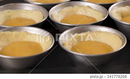 Unbaked Portuguese Egg Tarts in Metal Molds Unbaked Portuguese Egg Tarts in Metal Molds 141778208