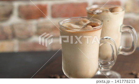 Iced Coffee Drinks in Glass Mugs with Handles Against a Brick Wall Iced Coffee Drinks in Glass Mugs with Handles Against a Brick Wall 141778215