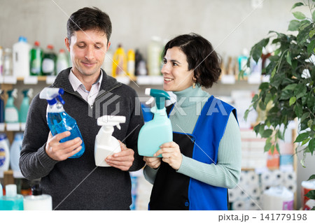 Female salesperson helps man choose best spray glass cleaner 141779198