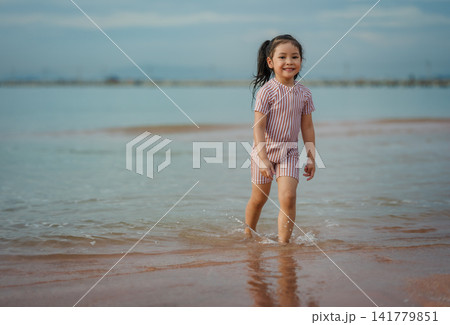 happy preschool child girl walking on sea beach in Pattaya, Thailand happy preschool child girl walking on sea beach in Pattaya, Thailand 141779851