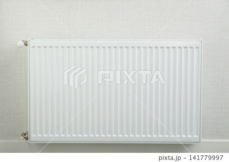 Heating season. Radiator heater provides warmth in cozy home environment Heating season. Radiator heater provides warmth in cozy home environment 141779997