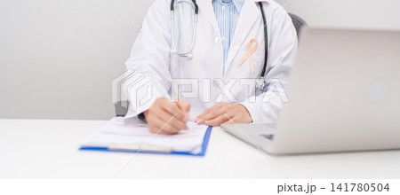 doctor using laptop and report notes on notebook. peach ribbon concept of September Uterine Cancer Awareness month, Endometrial, Gynecologic, Uterus and Ovaries, Endometriosis, June Vaginal cancer doctor using laptop and report notes on notebook. peach ribbon concept of September Uterine Cancer Awareness month, Endometrial, Gynecologic, Uterus and Ovaries, Endometriosis, June Vaginal cancer 141780504
