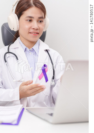 doctor using laptop for telehealth, online consultation and meeting about purple and pink ribbon concept of September Thyroid Cancer Awareness month, Healthcare and February world cancer day 141780517