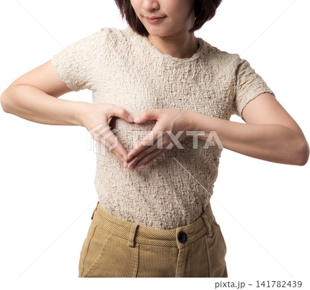 Asian woman forming heart gesture in textured shirt isolated against transparent background Asian woman forming heart gesture in textured shirt isolated against transparent background 141782439