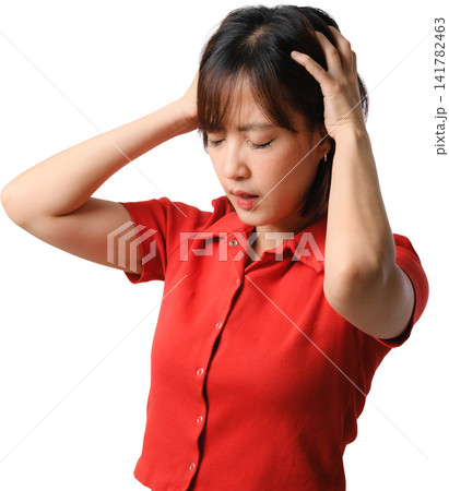 Asian woman experiencing headache while holding head in pain against isolated background with red shirt and emotional expression Asian woman experiencing headache while holding head in pain against isolated background with red shirt and emotional expression 141782463