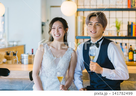 シャンパンで乾杯する新郎新婦 ウエディング シャンパンで乾杯する新郎新婦 ウエディング 141782499