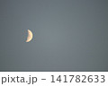 夕暮れの空に浮かぶ白い月 141782633