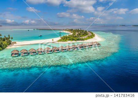 Spectacular summer aerial tropical island fringed by overwater villas turquoise lagoon Maldives luxury resort. Perfect vacation travel landscape paradise. Luxury honeymoon getaway scenic Spectacular summer aerial tropical island fringed by overwater villas turquoise lagoon Maldives luxury resort. Perfect vacation travel landscape paradise. Luxury honeymoon getaway scenic 141783416