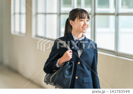 学校の廊下を歩く制服姿の小学生,中学生,高校生の女子生徒 141783549