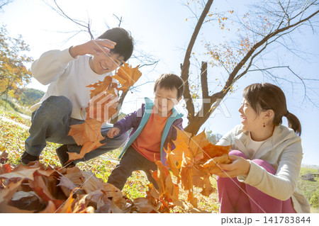 紅葉の公園で遊ぶ3人家族 紅葉の公園で遊ぶ3人家族 141783844