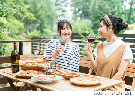 テラスで食事,バーベキュー,ホームパーティー,グランピングする若い女性,友達 テラスで食事,バーベキュー,ホームパーティー,グランピングする若い女性,友達 141784151