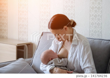 Young mother breastfeeding newborn baby at home Young mother breastfeeding newborn baby at home 141784236